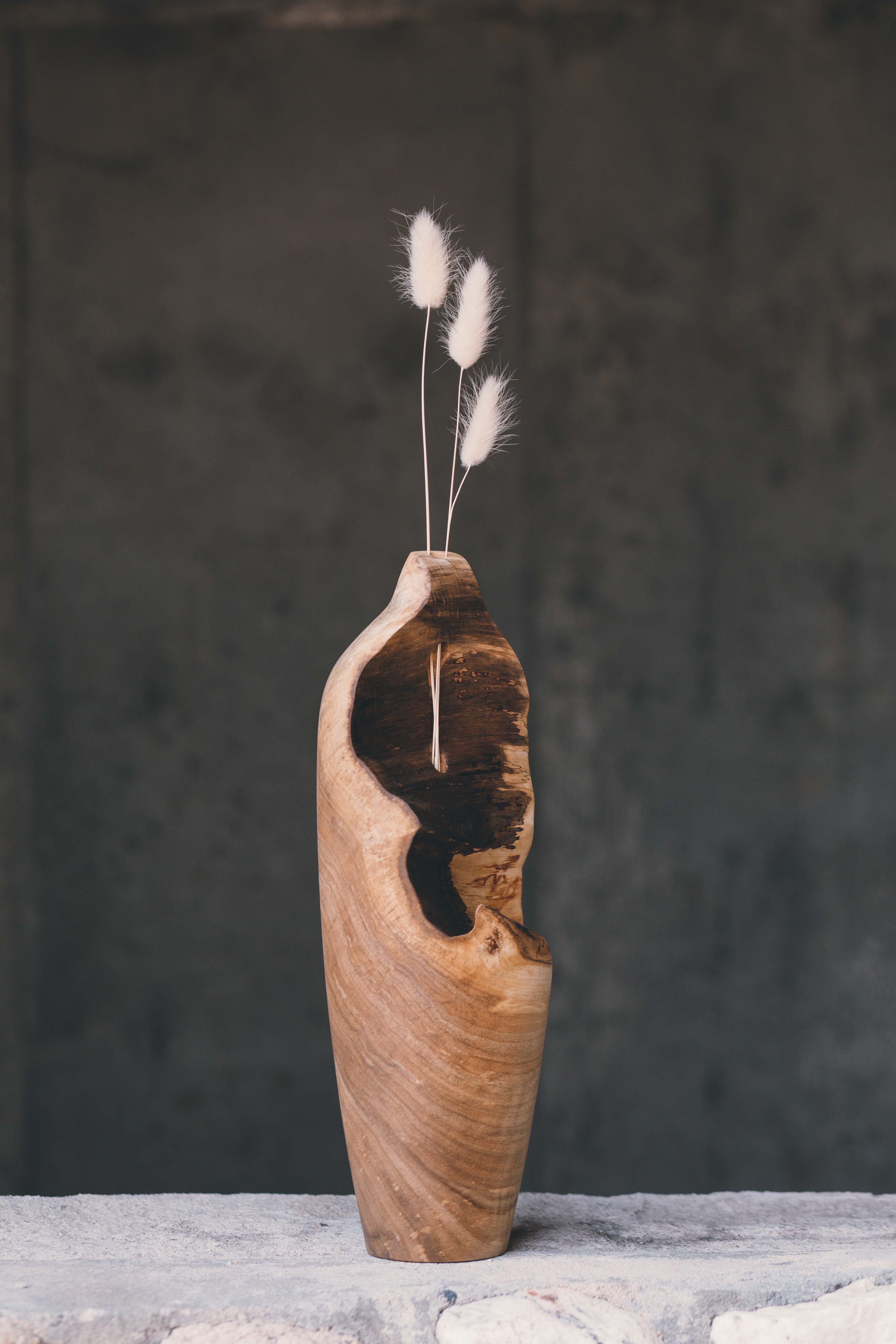 wooden tall classic shaped budvase with a cavernous bark inclusion and an opening for dried floral stems.